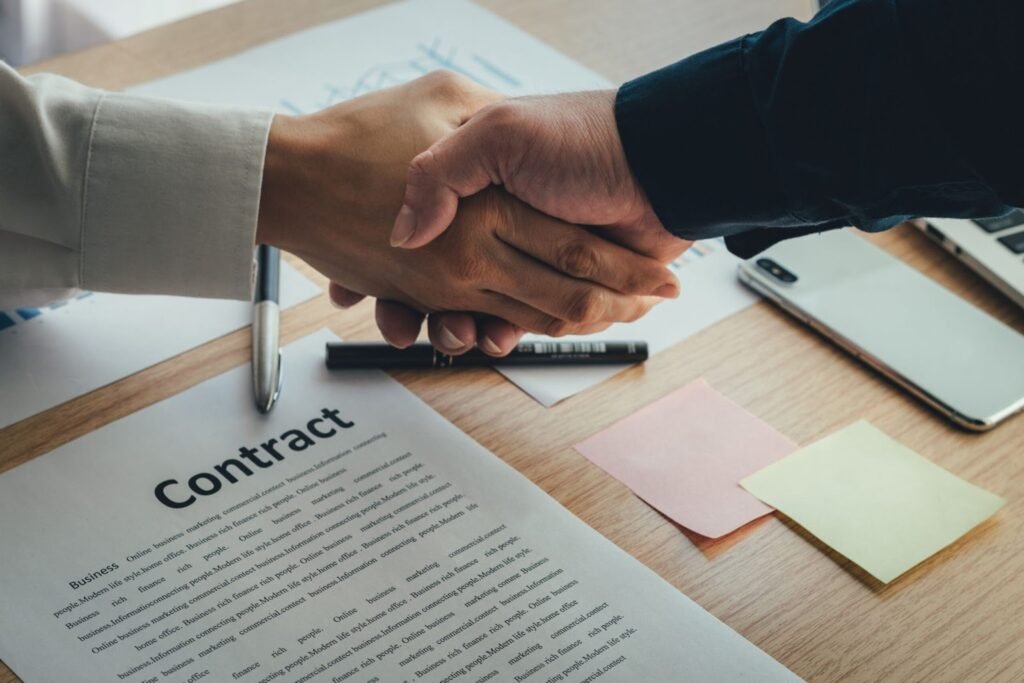 Two people shaking hands after finalizing a contract.