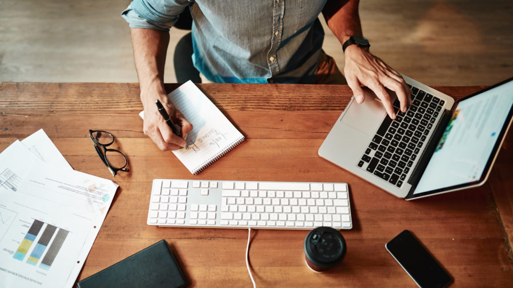 a person is working on laptop and notebook