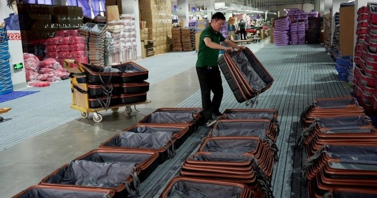 An individual inspecting each suitcase bag one by one.