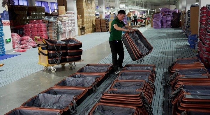 An individual inspecting each suitcase bag one by one.