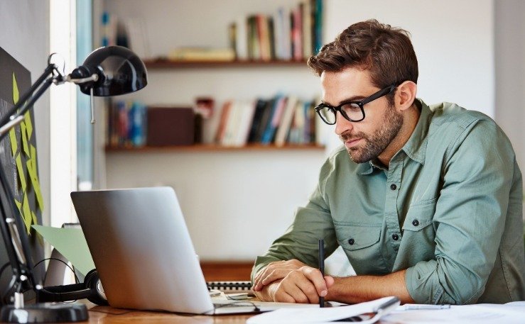 An image showing a person working on a laptop.
