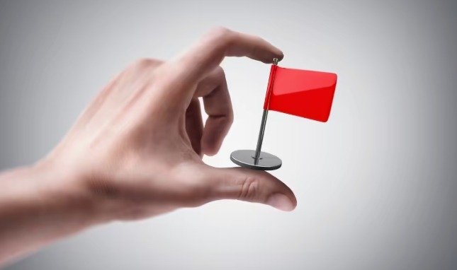 a person is holding red flag in hand
