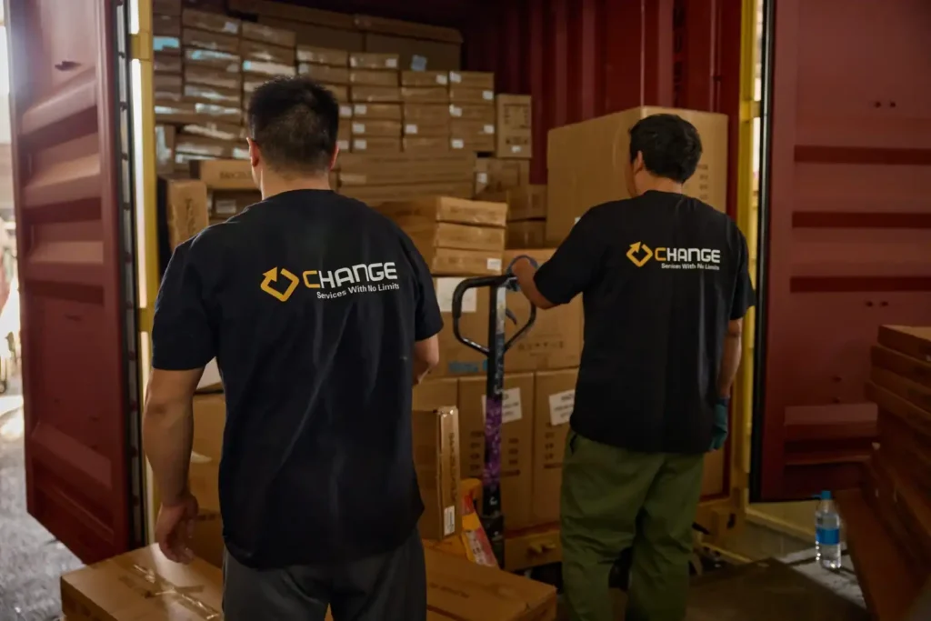Change Sourcing team members loading cartons into a shipping container, showing warehouse shipment handling after inspection and quality control review.