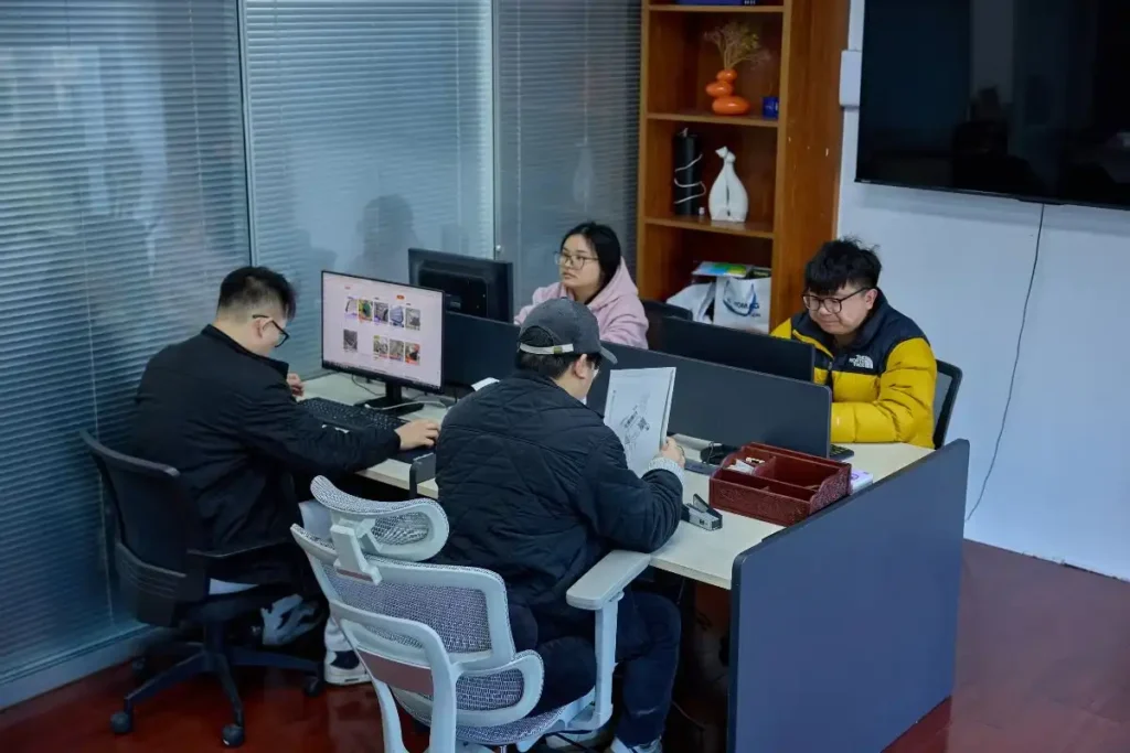 Change Sourcing team members working together in an office, reviewing supplier details and product sourcing plans to help Indian importers access China correctly.